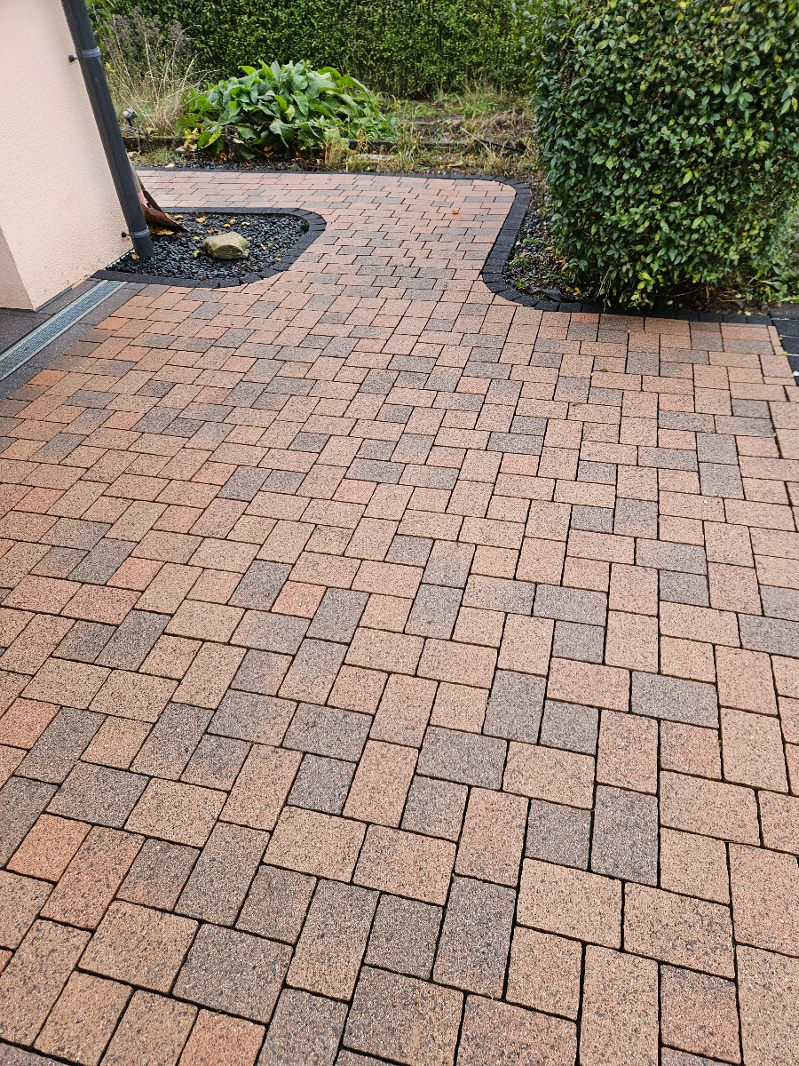 Sauber gereinigte Pflastersteine auf Einfahrt mit klarem Strukturkontrast – Reinigung pflastersteine