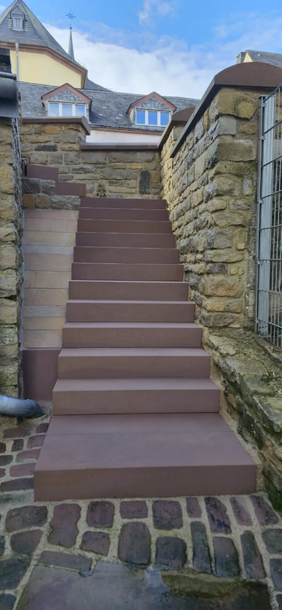 Sauber gereinigte Natursteintreppe zwischen rustikalen Steinmauern nach Treppenreinigung